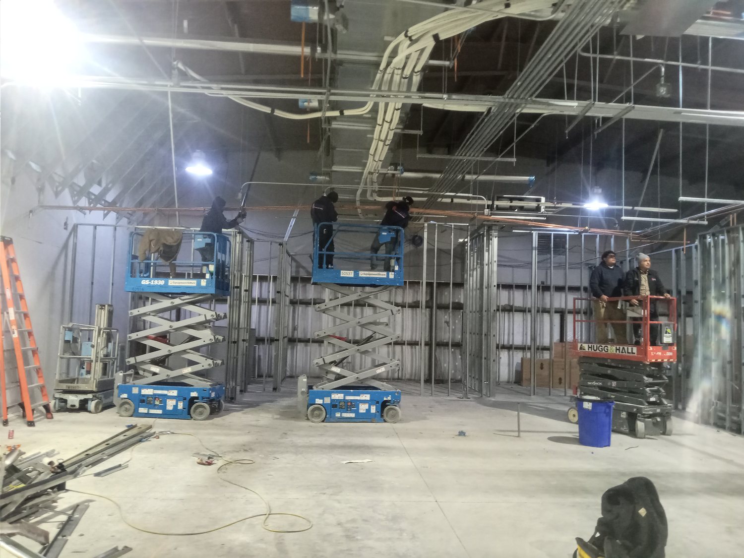 Dense overhead mechanical, electrical and plumbing rough-in above the framed rooms