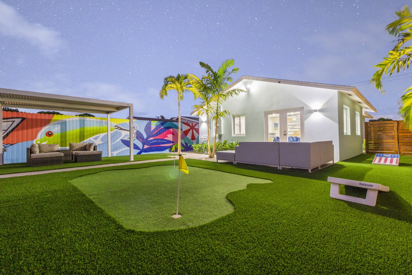 The backyard after: putting green, turf, pergola lounge and painted murals