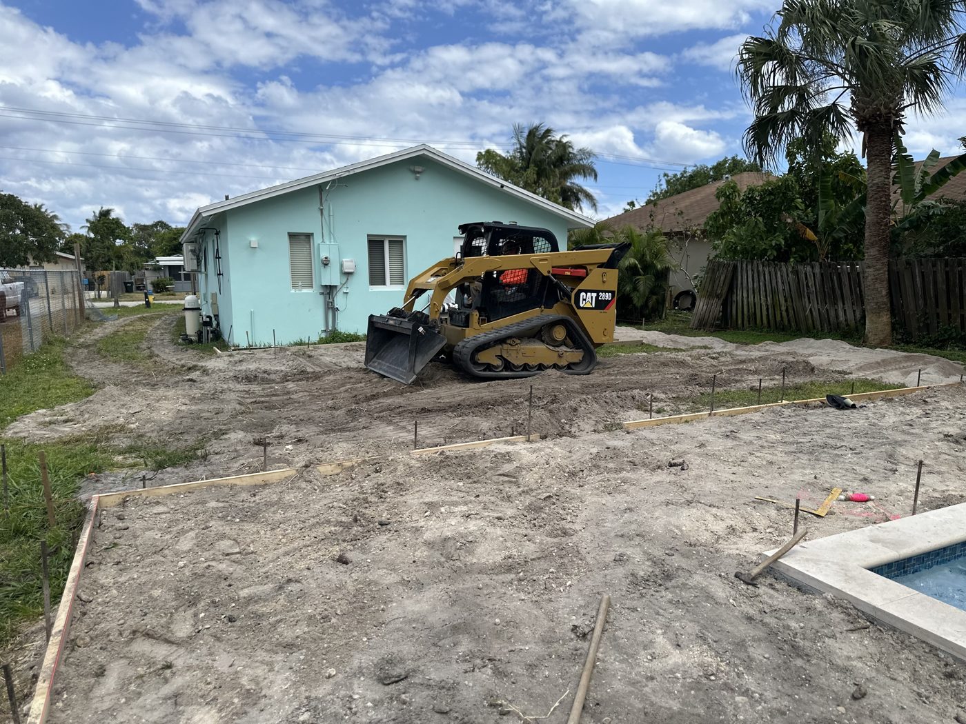 The backyard before: bare dirt and a skid steer during site work