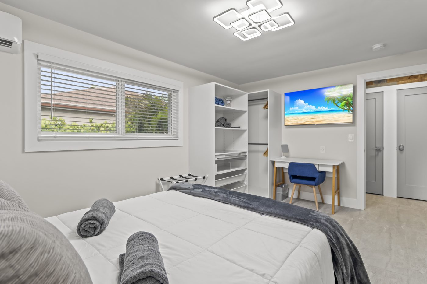 Bedroom with desk, wall-mounted TV and built-in shelving