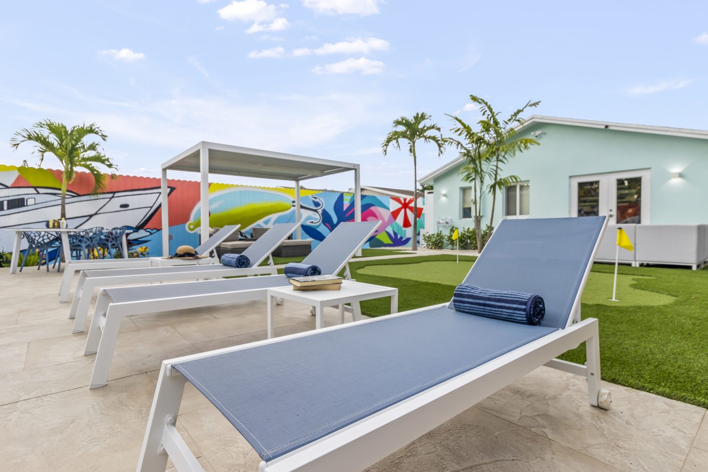 Sun loungers on the deck with turf and putting green beyond