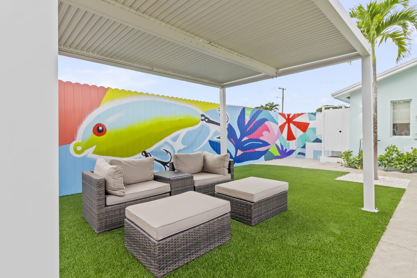 Wicker lounge set under the pergola with the mural behind