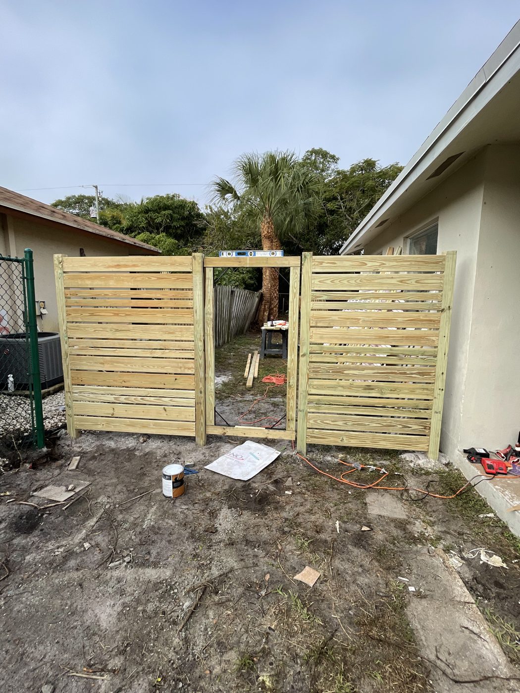 New horizontal wood fence and gate going up beside the house