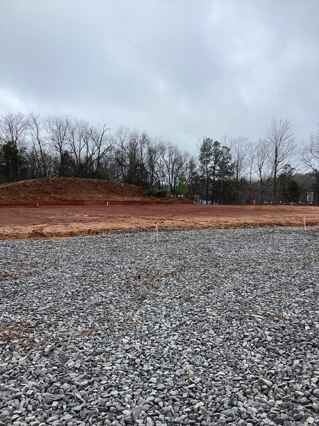 Compacted gravel sub-base spread across the building pad