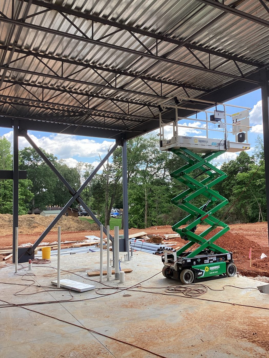 Steel columns and roof joists with a scissor lift working below