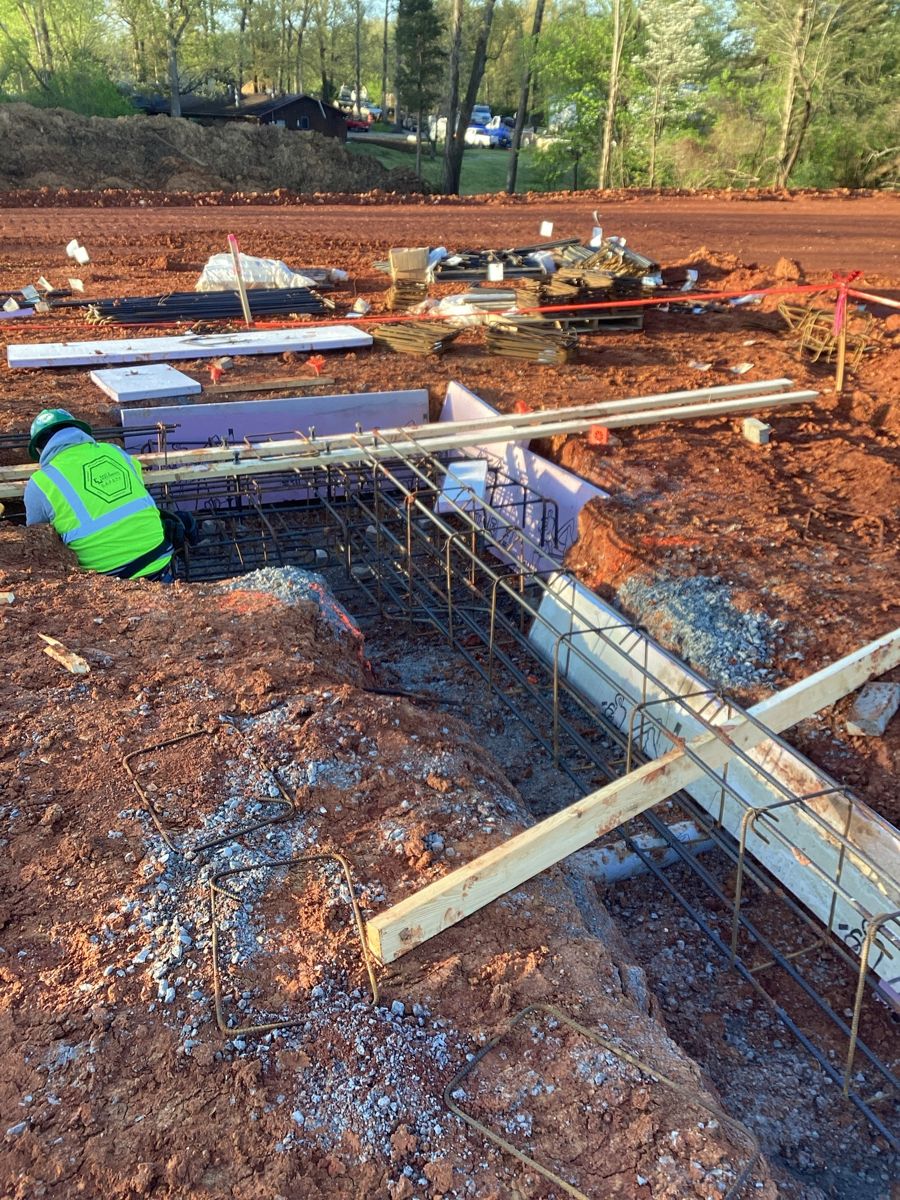 Footing forms and rebar cages laid out in the trenches