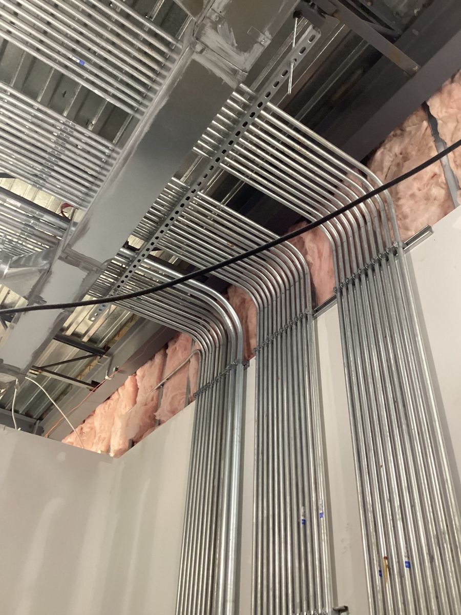Conduit runs bent up the wall and across the ceiling