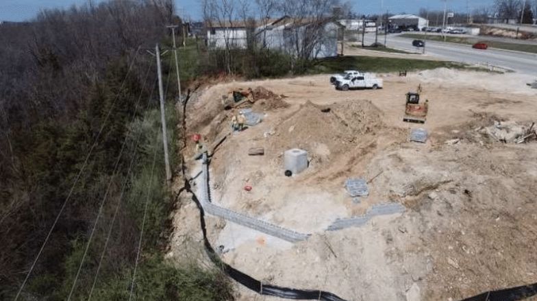 Aerial view of the cleared site with silt fence and drainage line