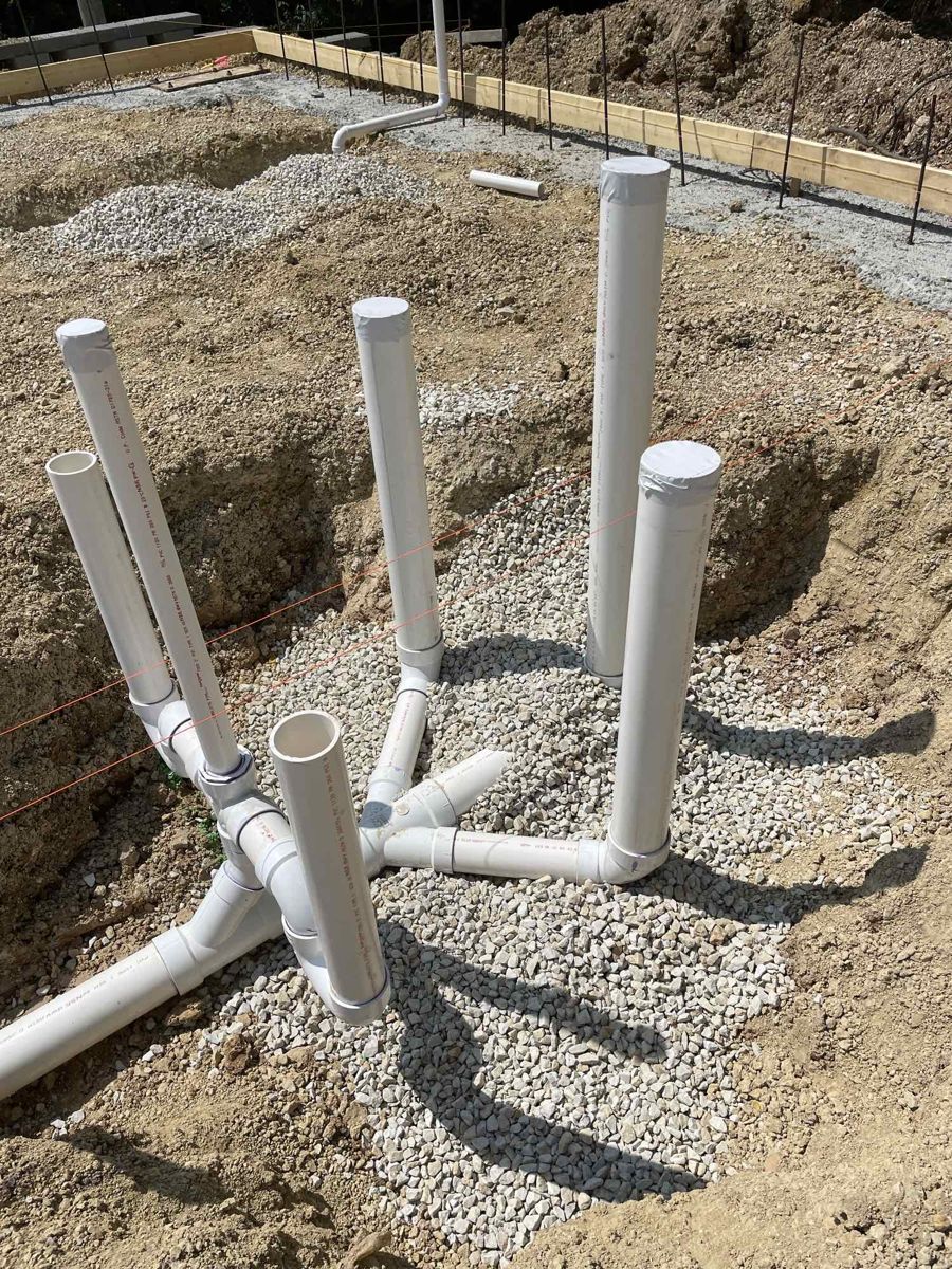 Underground plumbing stub-ups set in gravel before the slab pour