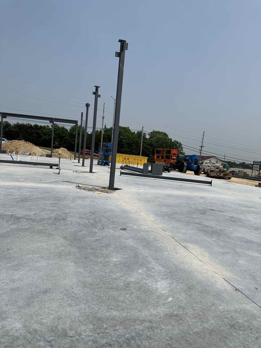 First structural steel columns standing on the new slab