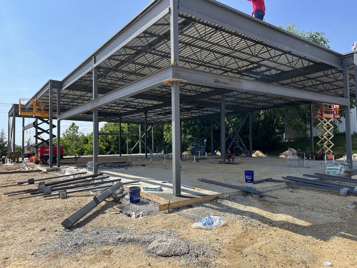 Steel frame with roof deck in place and lifts working below