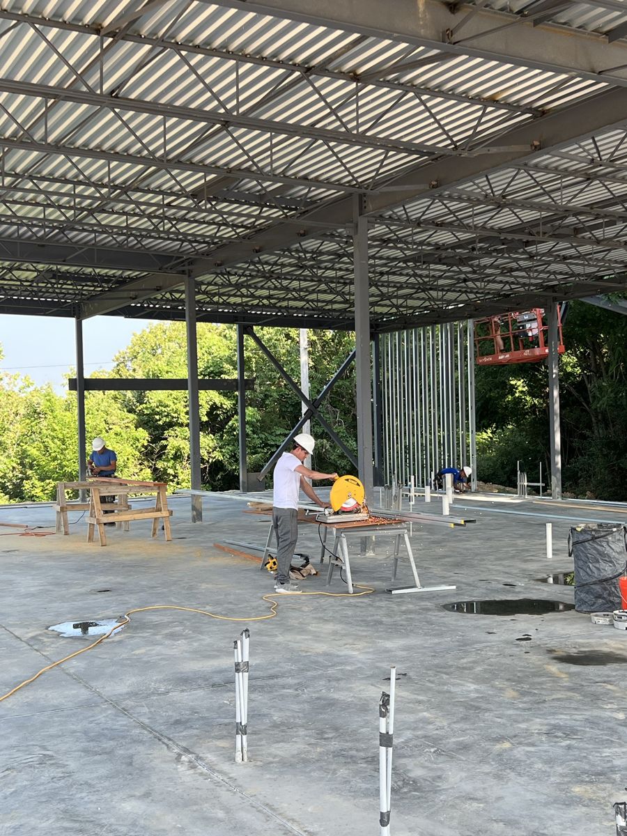 Crew cutting metal studs under the new roof deck