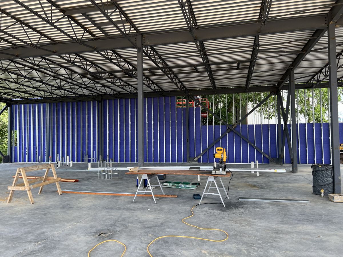Exterior wall panels and blue insulation board going in under the steel deck