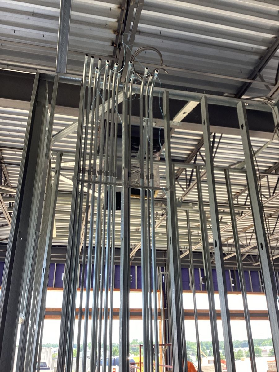 Electrical conduit stubs rising through the metal stud framing