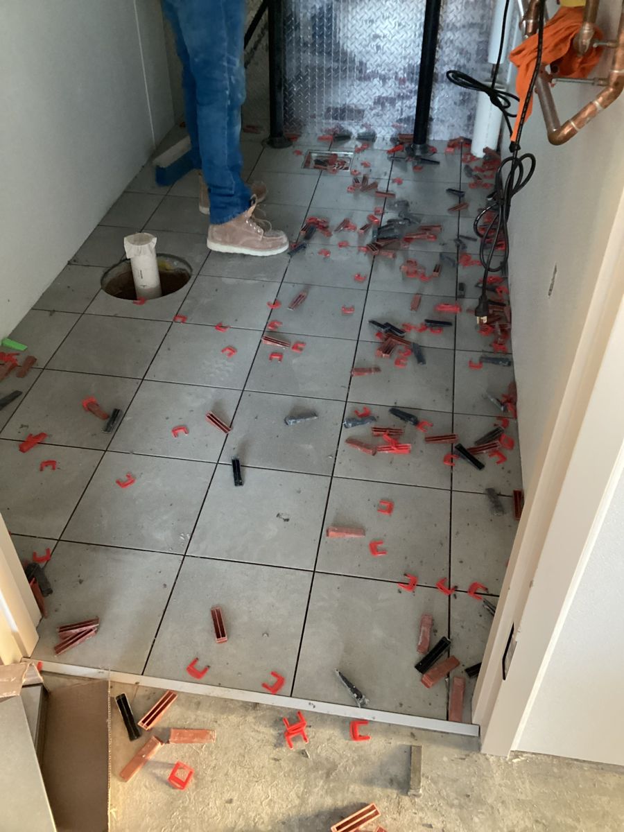 Restroom floor tile set with leveling clips