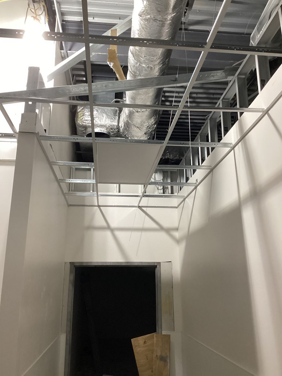 Ceiling grid and ductwork above a corridor opening