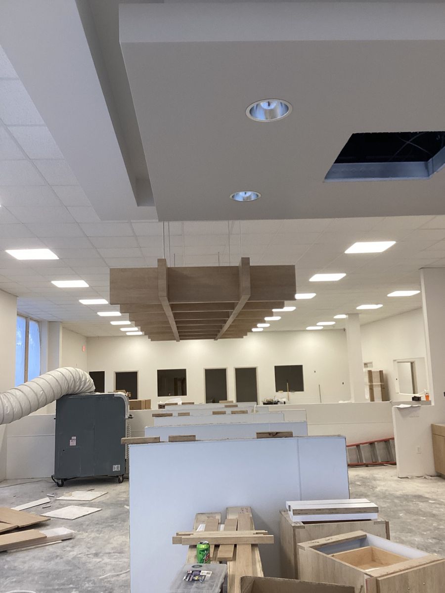 Wood baffle ceiling being hung over the donor floor during fit-out