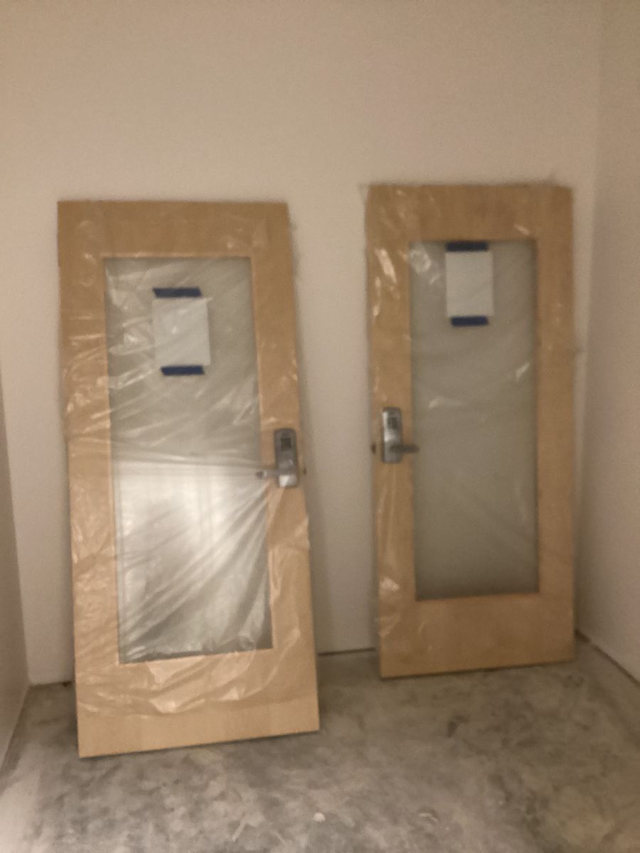 Wood doors with glass lites staged for hanging