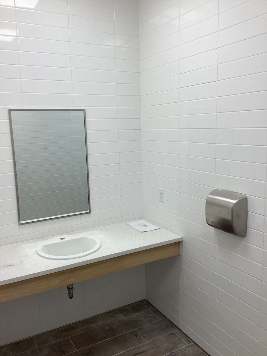Finished restroom with subway tile and quartz vanity